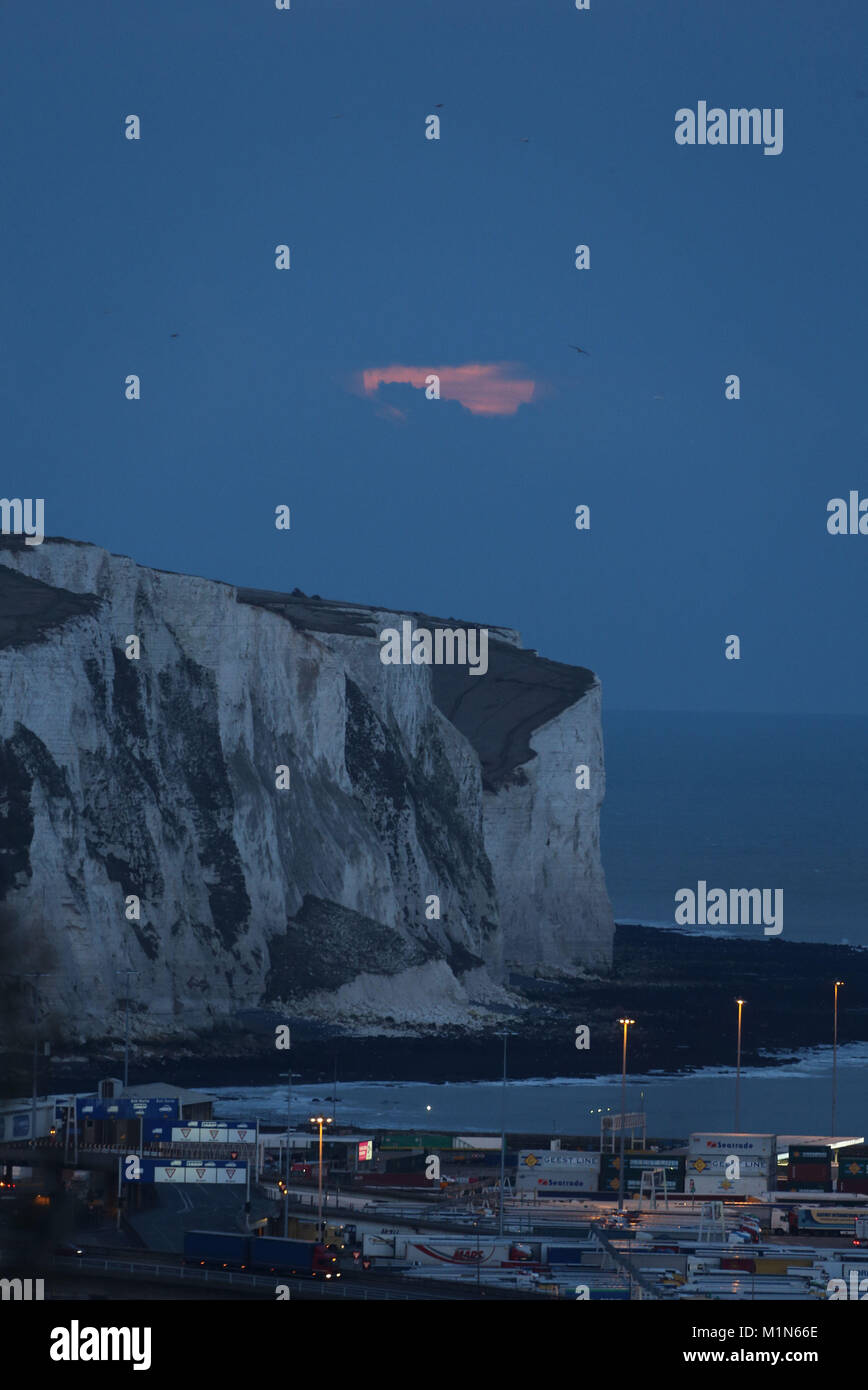 Der Mond wird durch Wolken gesehen steigt über den weißen Klippen von Dover vor einem "ungewöhnlichen" Himmelsereignis am Mittwochabend, wenn ein Blauer Mond zum ersten Mal seit Juli 2015 am Himmel aufsteigen wird. Stockfoto