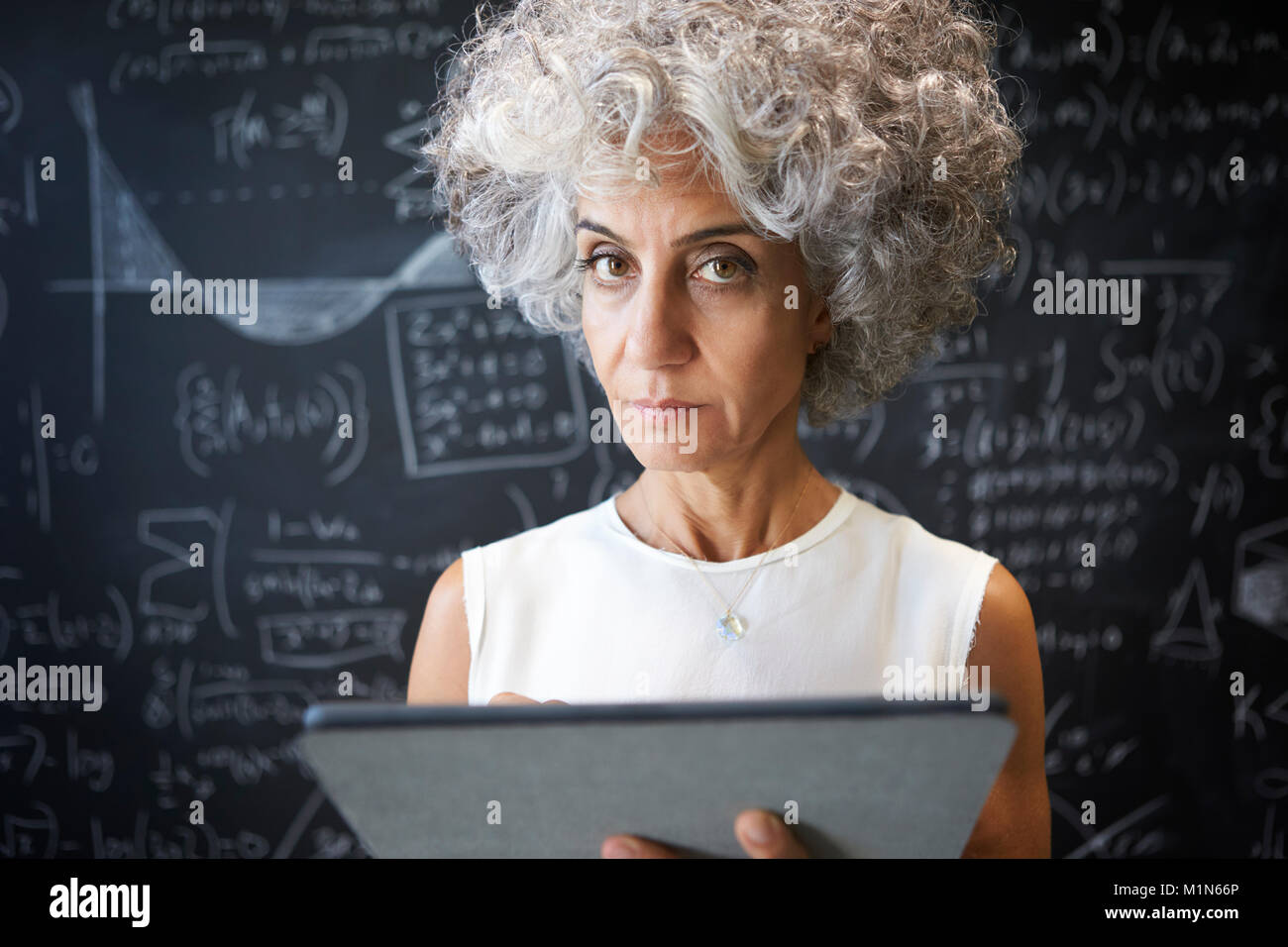 Akademische Frau mittleren Alters mit Tablet-PC auf die Kamera Stockfoto