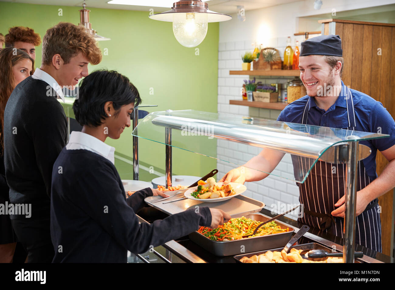 Teenage Schüler serviert Essen in der Schulkantine Stockfoto