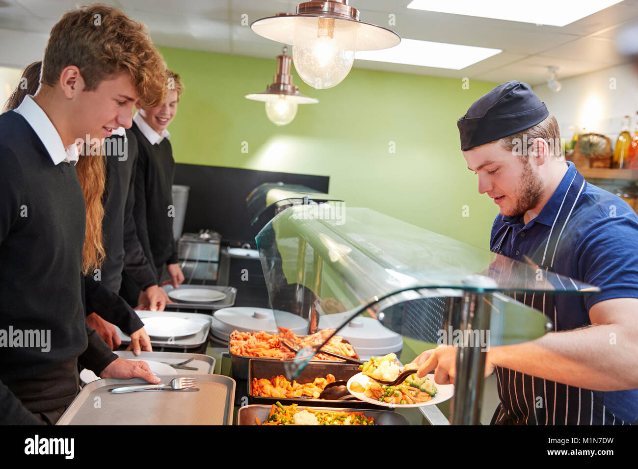Teenage Schüler serviert Essen in der Schulkantine Stockfoto