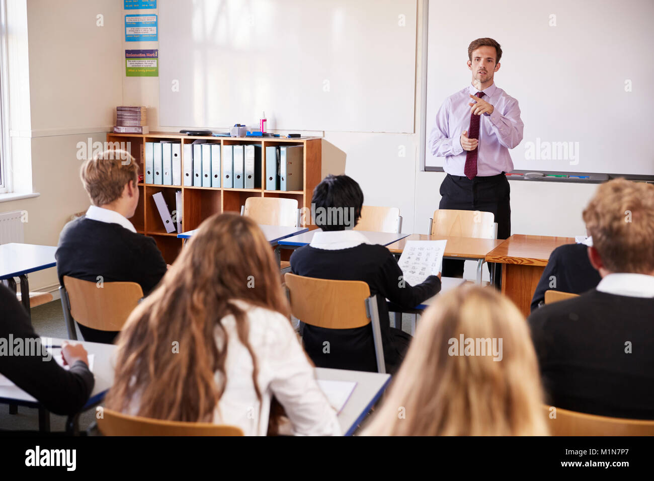 Teenage Studenten hören auf männliche Lehrer im Klassenzimmer Stockfoto