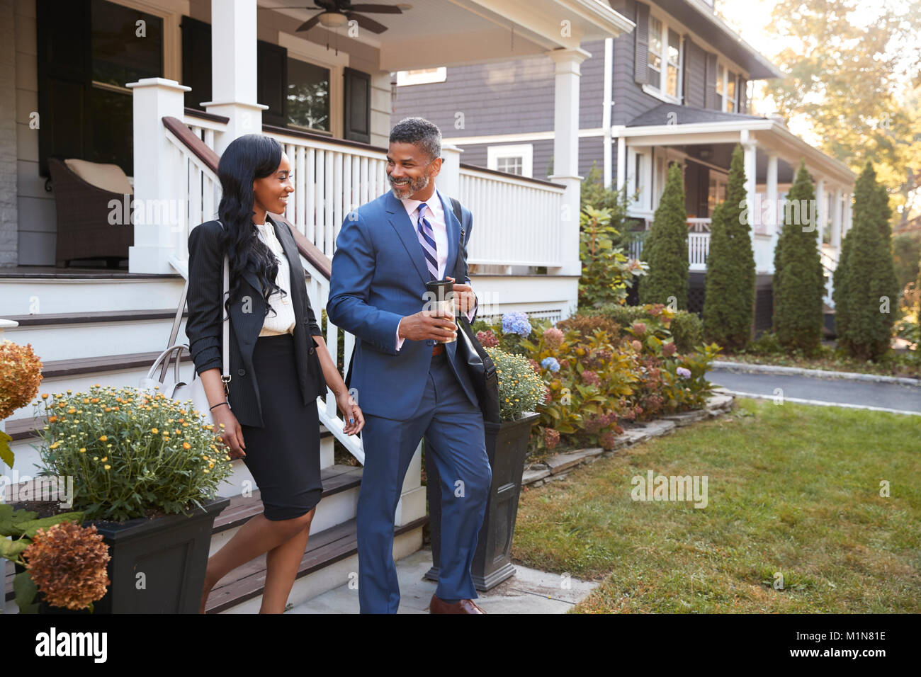 Business Paar verlassen Suburban House für den Weg zur Arbeit Stockfoto