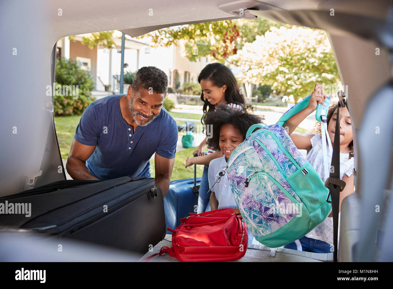 Familie verlassen für Ferienhäuser Laden das Gepäck ins Auto Stockfoto