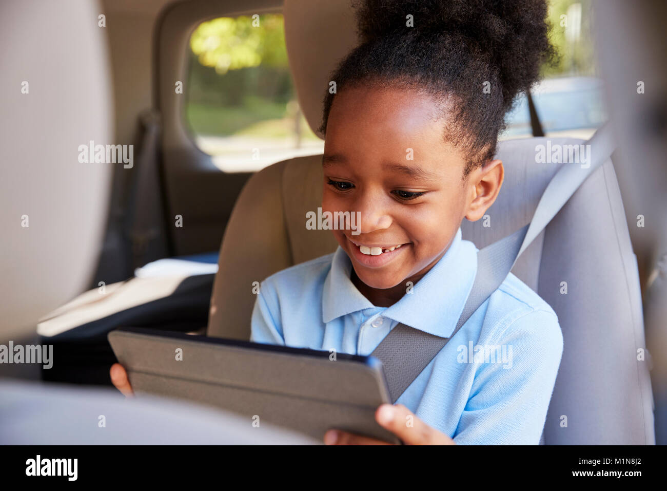 Junge mit digitalen Tablette auf dem Auto Stockfoto