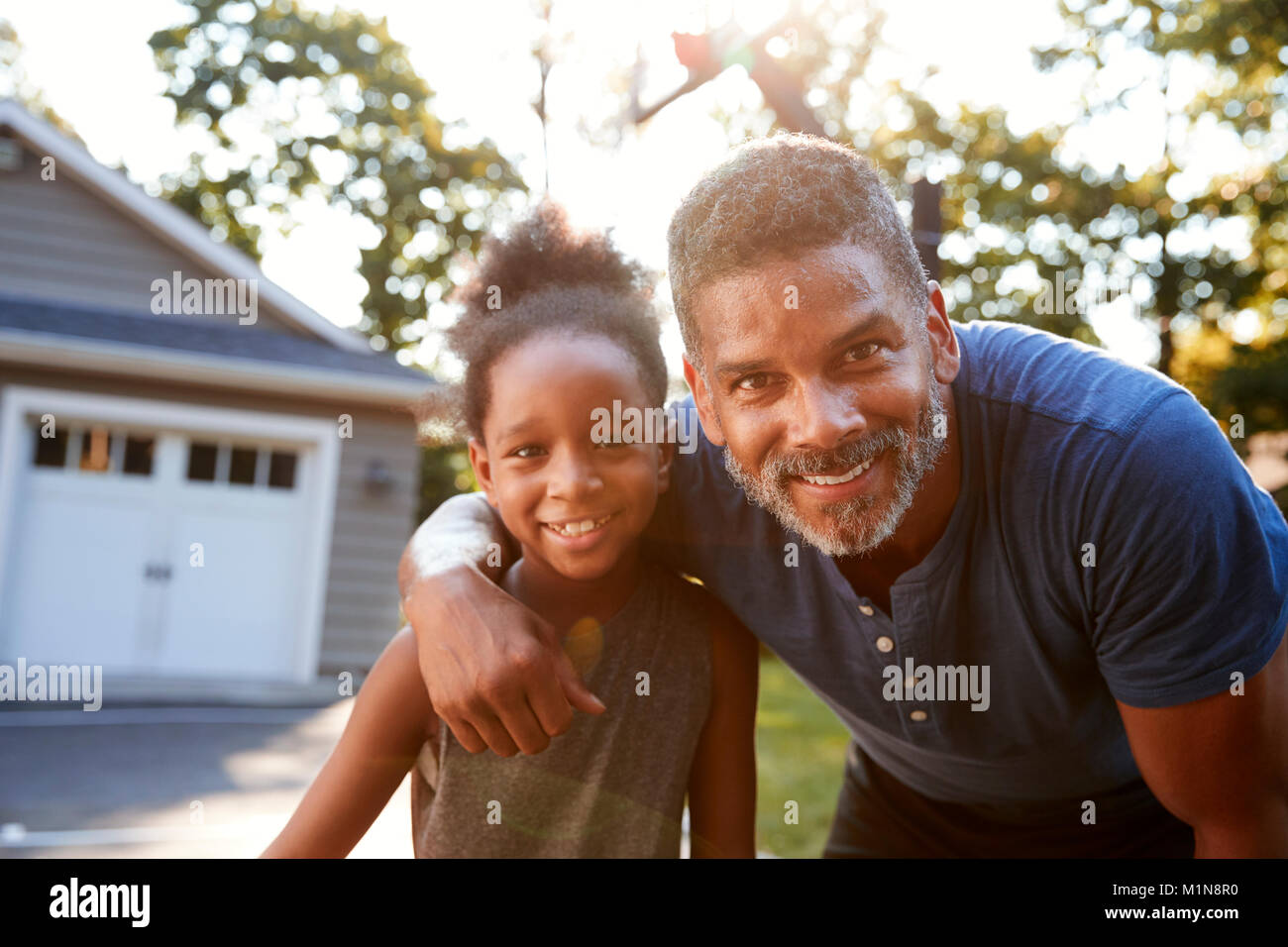 Portrait von Vater und Sohn spielen Basketball in der Einfahrt Stockfoto