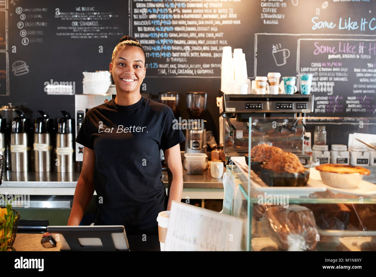 Portrait von weiblichen Barista hinter Zähler in Coffee Shop Stockfoto