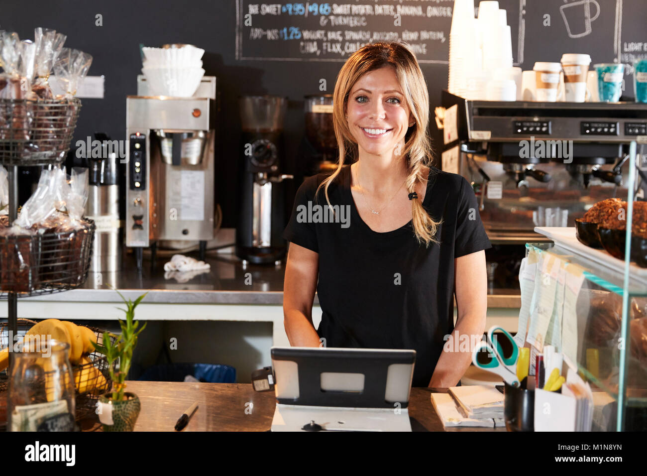 Portrait von weiblichen Barista hinter Zähler in Coffee Shop Stockfoto