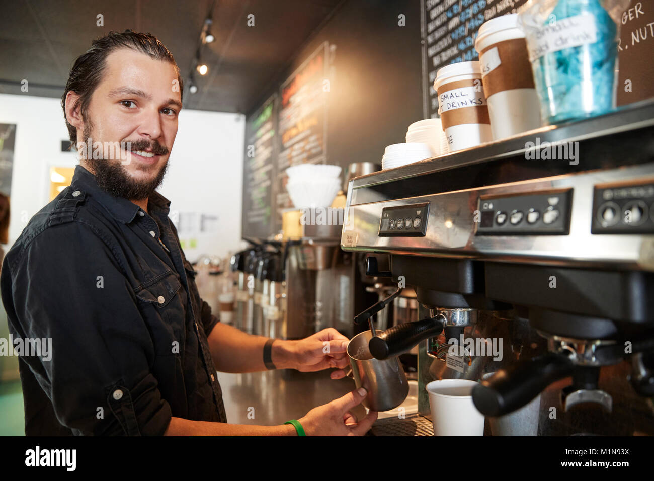 Portrait der männlichen Barista hinter Zähler in Coffee Shop Stockfoto