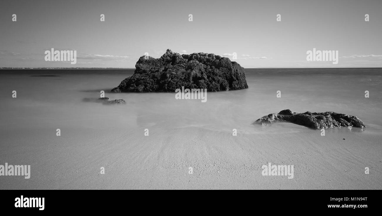 Strand mit türkisblauen Wasser Wasser mit Steinen. langen Belichtungszeit. Portugal Stockfoto