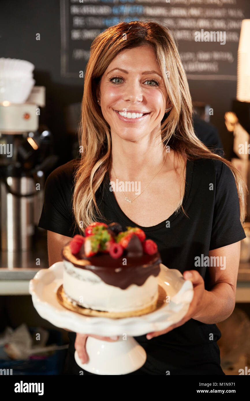Kellnerin mit frisch gebackenem Kuchen mit Buttercream Frosting Stockfoto