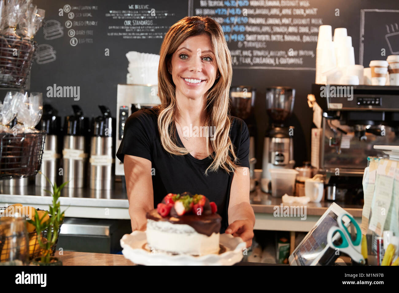 Kellnerin mit frisch gebackenem Kuchen mit Buttercream Frosting Stockfoto