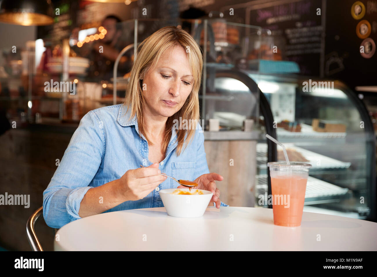 Frau im Café sitzen am Tisch essen Suppe Stockfoto