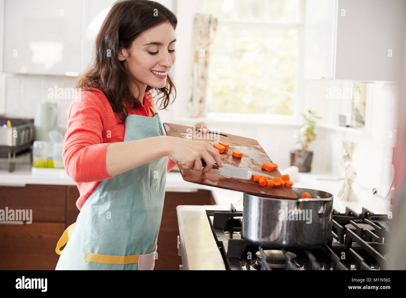Kochen Frau Karotten in der Küche für Jüdische Passamahl Stockfoto