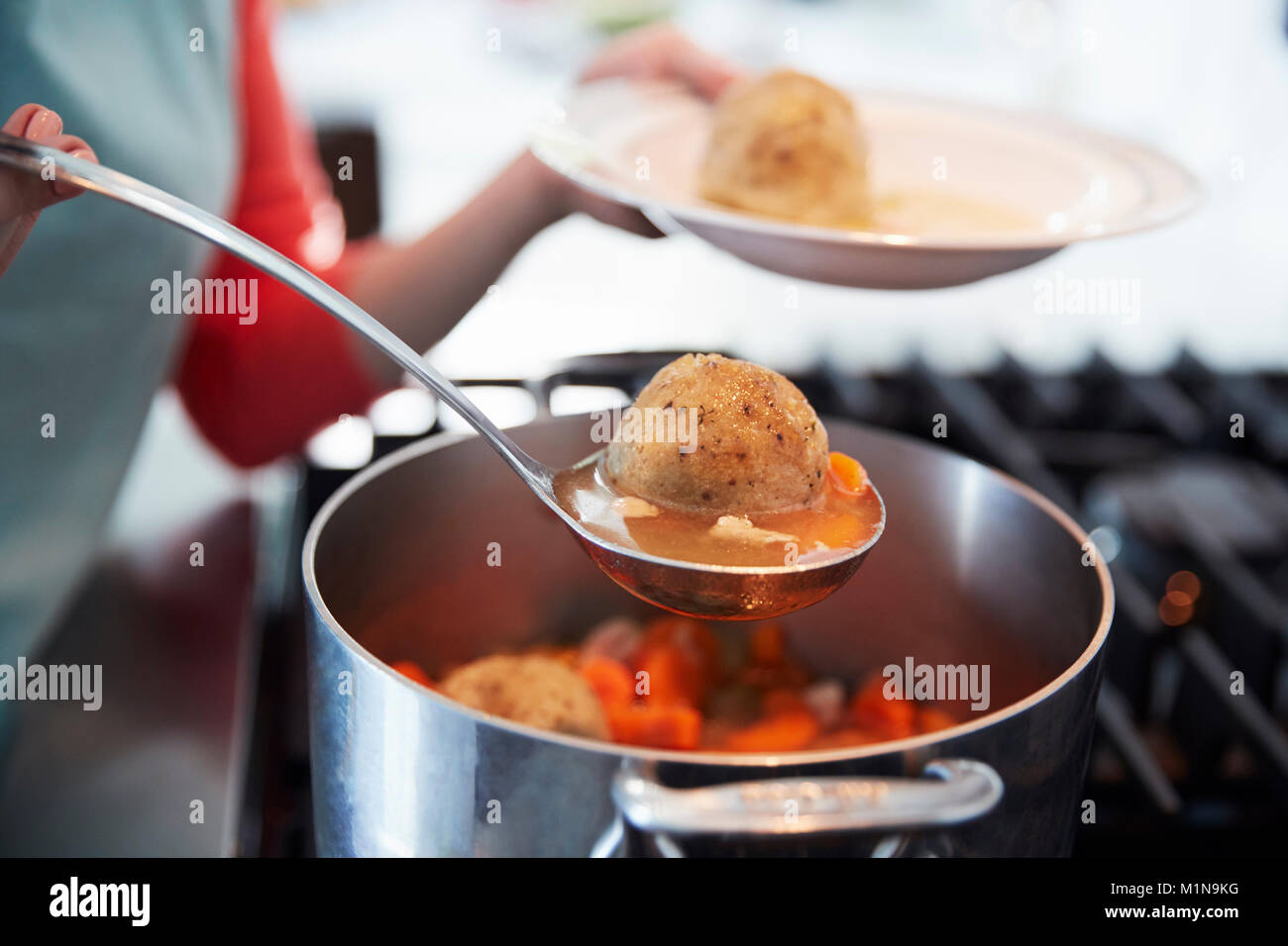 Frau Jüdischen matzon Suppe aus dem Topf, in der Nähe Stockfoto