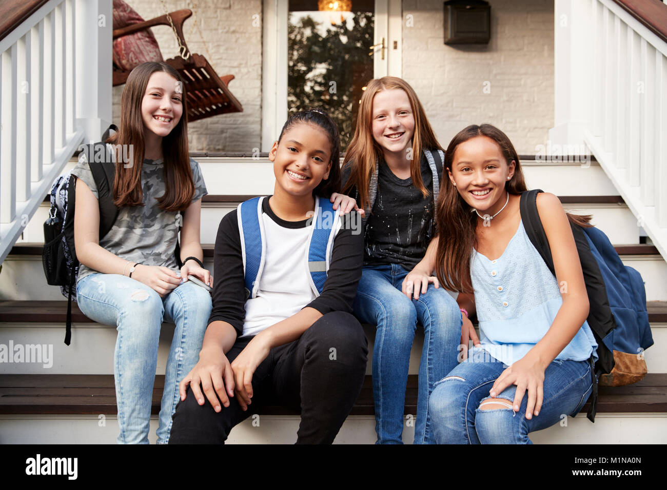 Junge Teen Girls auf Stufen vor dem Haus an der Kamera auf der Suche Stockfoto
