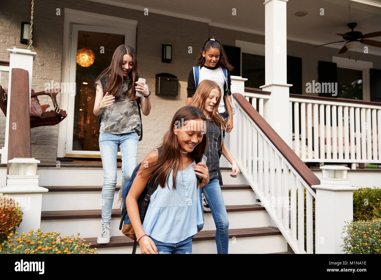 Vier jugendlich Freundinnen verlassen Haus für Schule Stockfoto