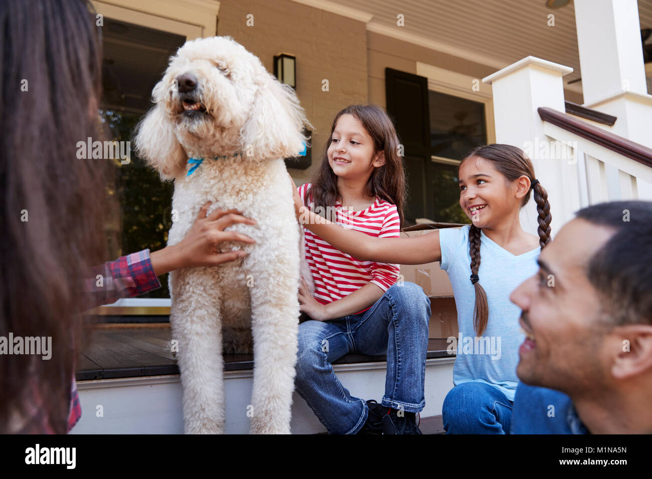 Familie mit Hund sitzen auf die Schritte der neuen Heimat unter Umzug in Tag Stockfoto