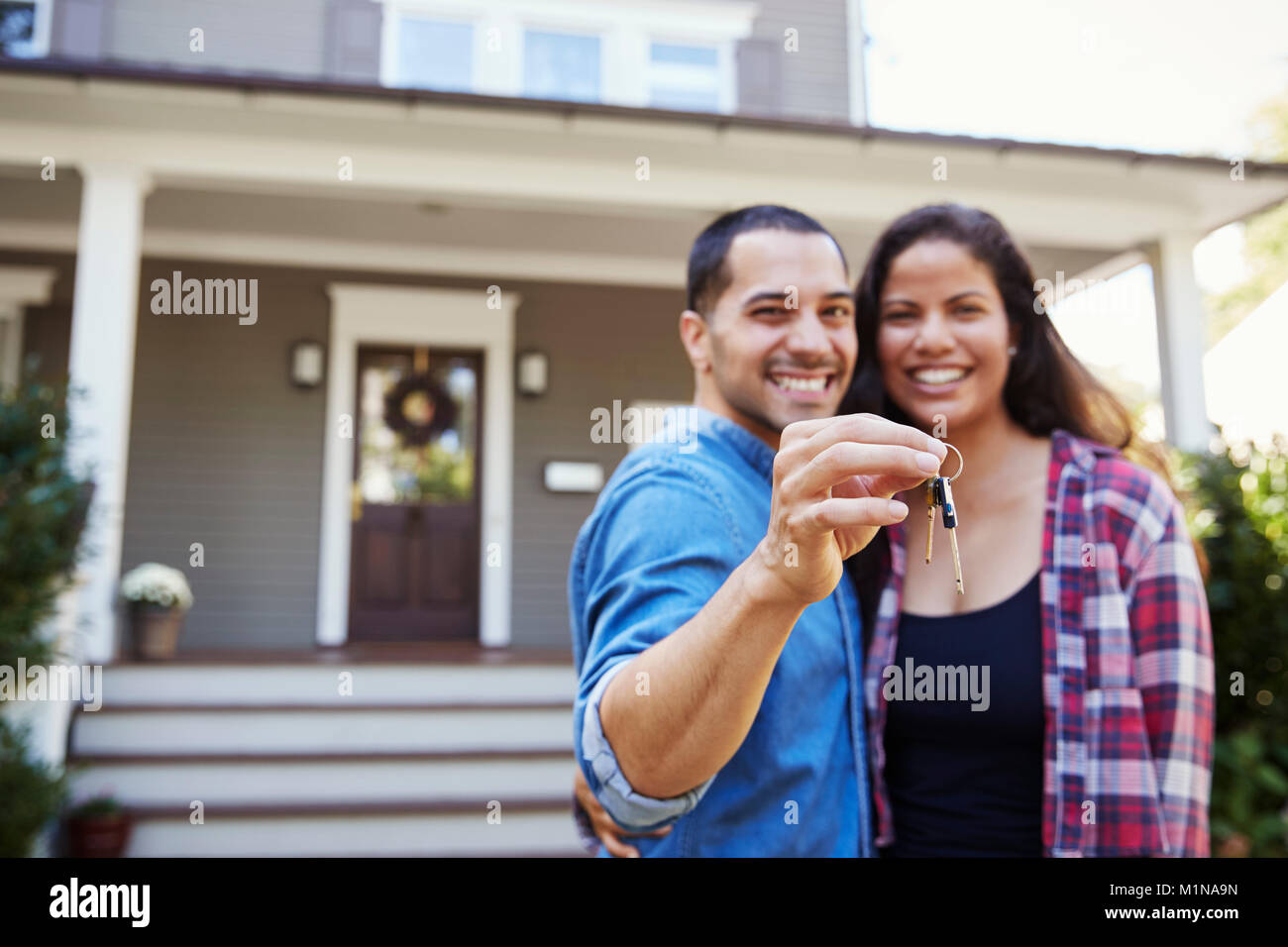 Portrait von Paar hält die Schlüssel zum neuen Haus unter Umzug in Tag Stockfoto