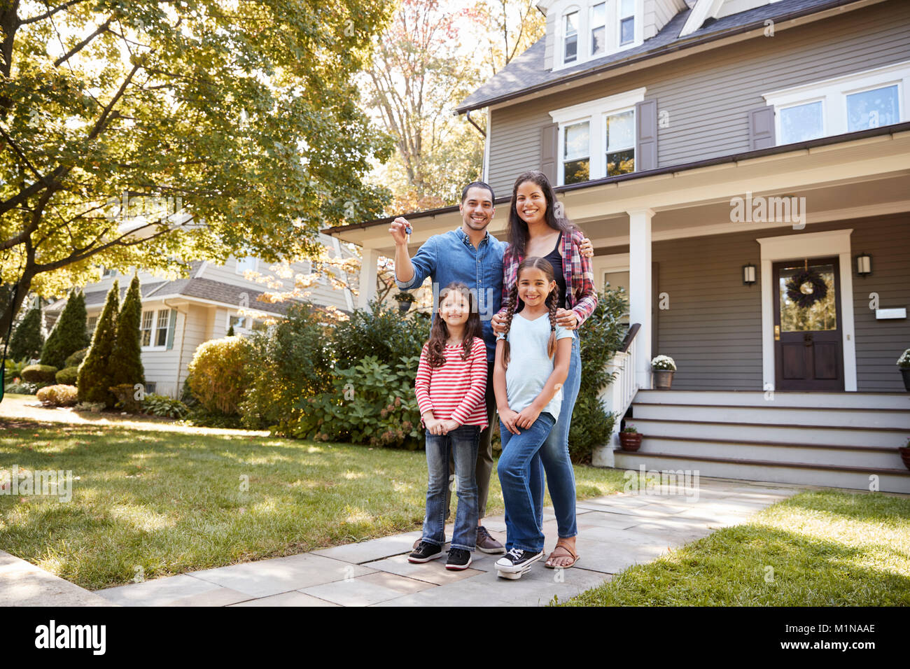 Porträt der Familie Holding Schlüssel zum neuen Haus unter Umzug in Tag Stockfoto