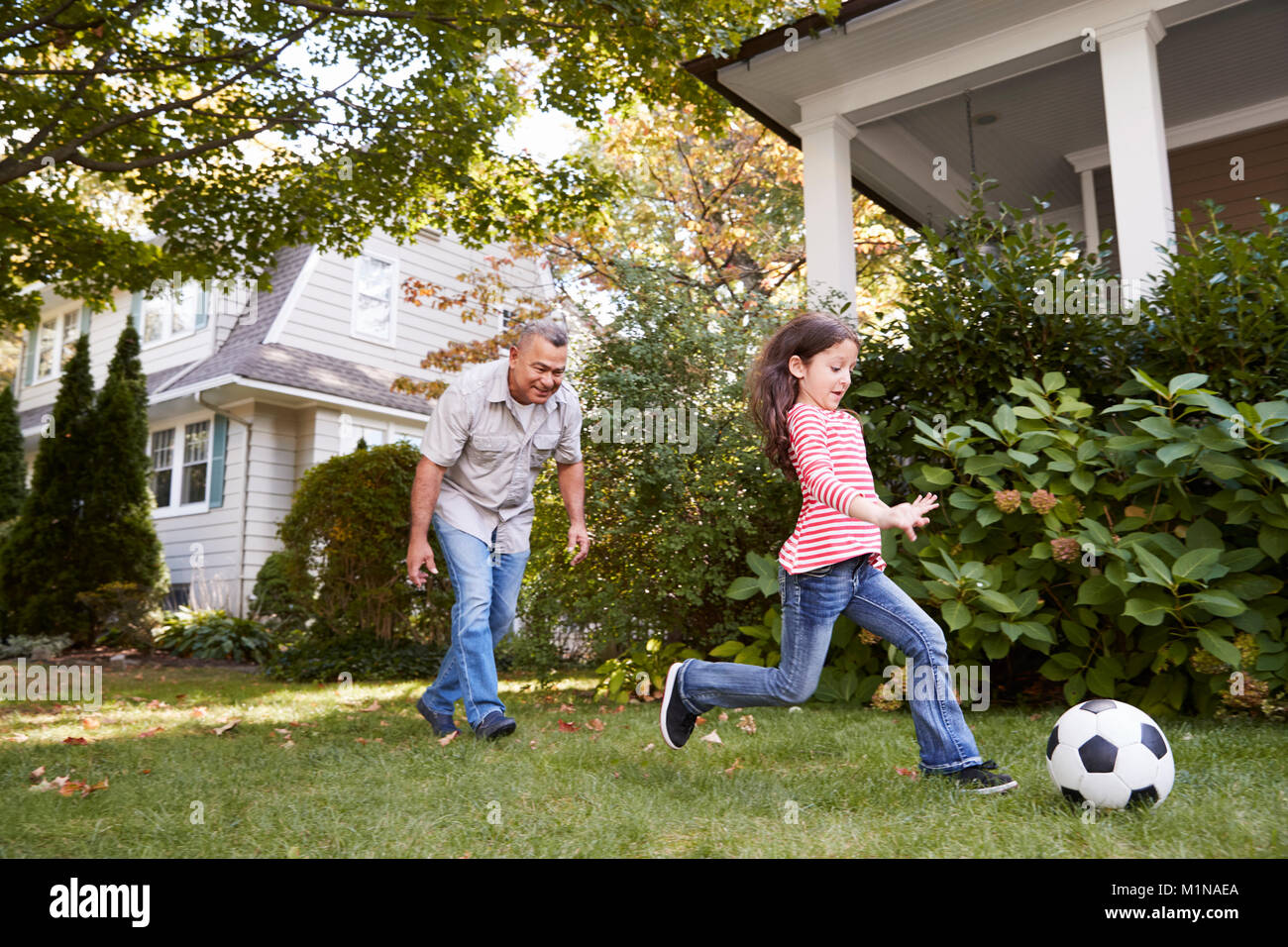 Großvater Fußball spielen im Garten mit Enkeltochter Stockfoto