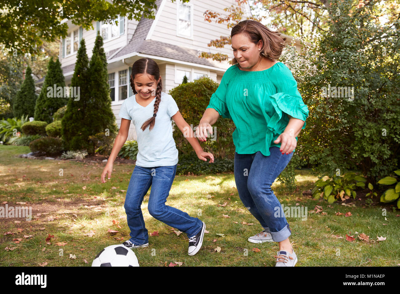 Großmutter Fußball spielen im Garten mit Enkeltochter Stockfoto
