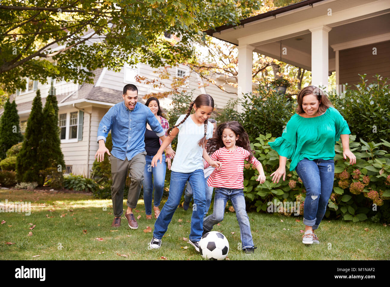 Multi-Generation Familie Fußball spielen im Garten Stockfoto