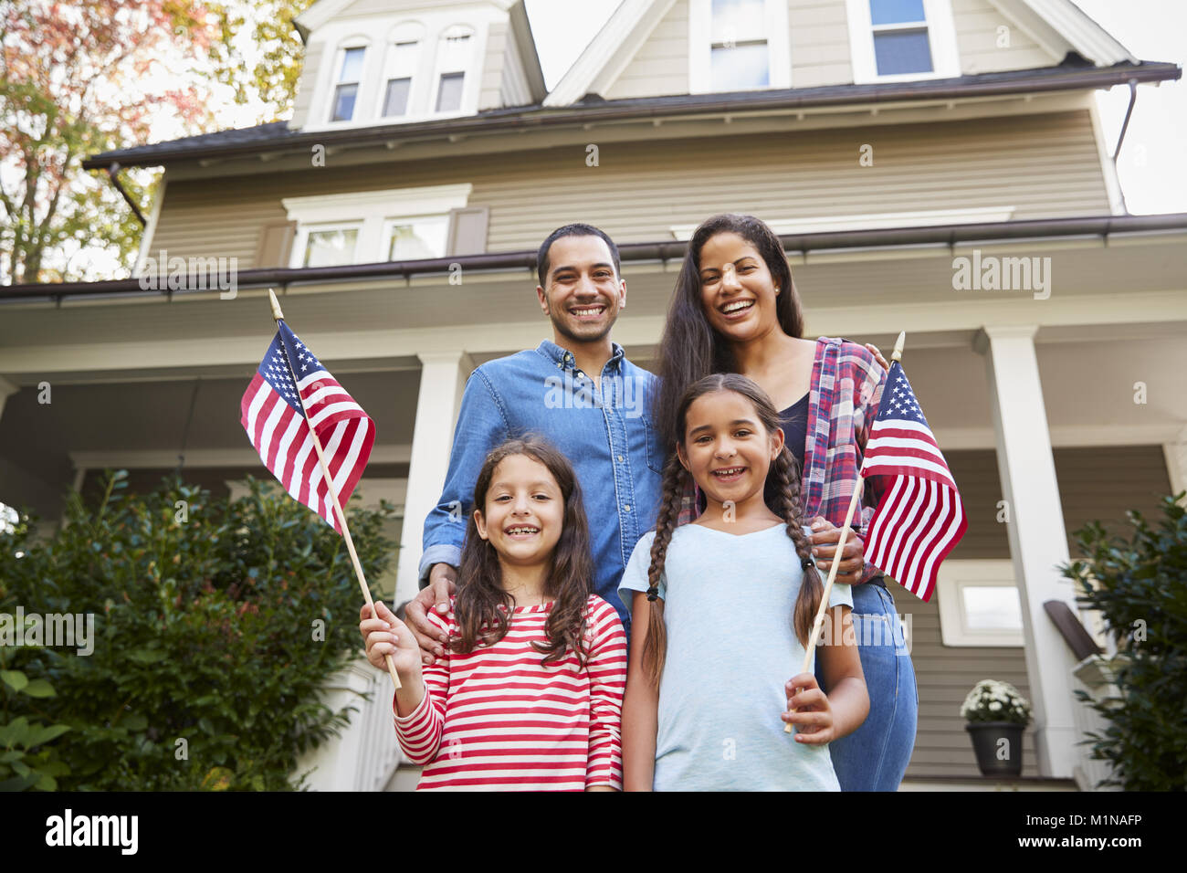 Porträt der Familie außer Haus halten amerikanische Flaggen Stockfoto