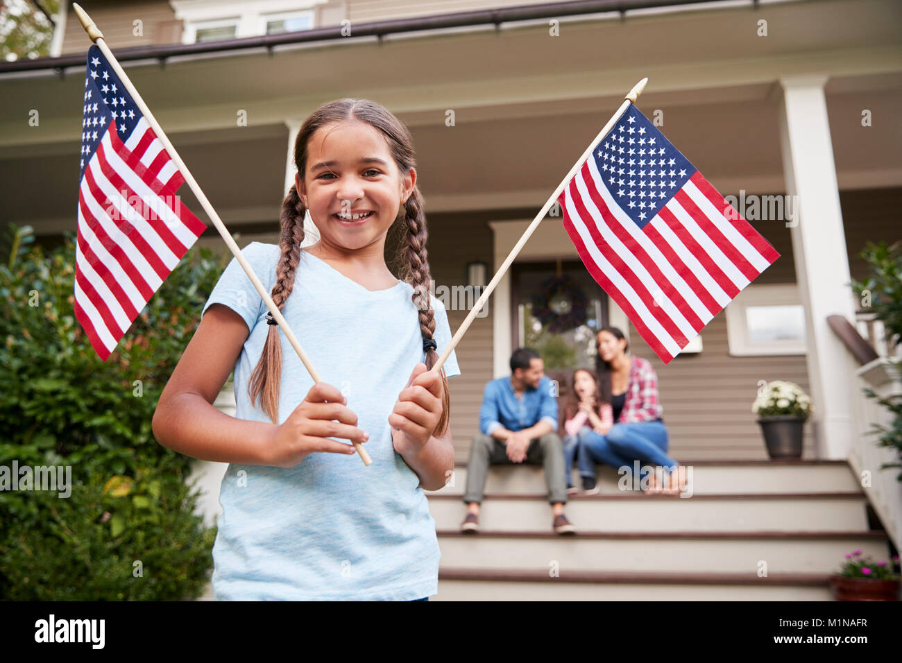 Portrait von Mädchen außerhalb der Familie zu Hause halten amerikanische Flaggen Stockfoto