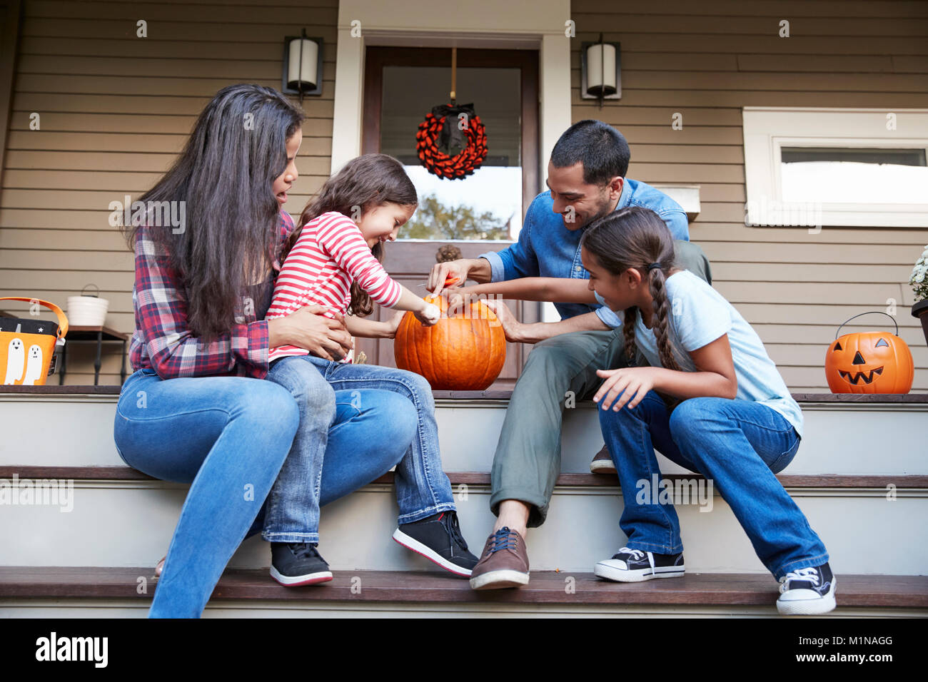 Familie schnitzen Halloween Kürbis auf Haus Schritte Stockfoto