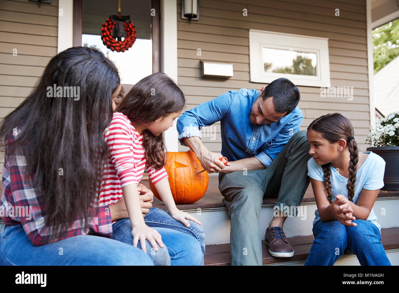 Familie schnitzen Halloween Kürbis auf Haus Schritte Stockfoto