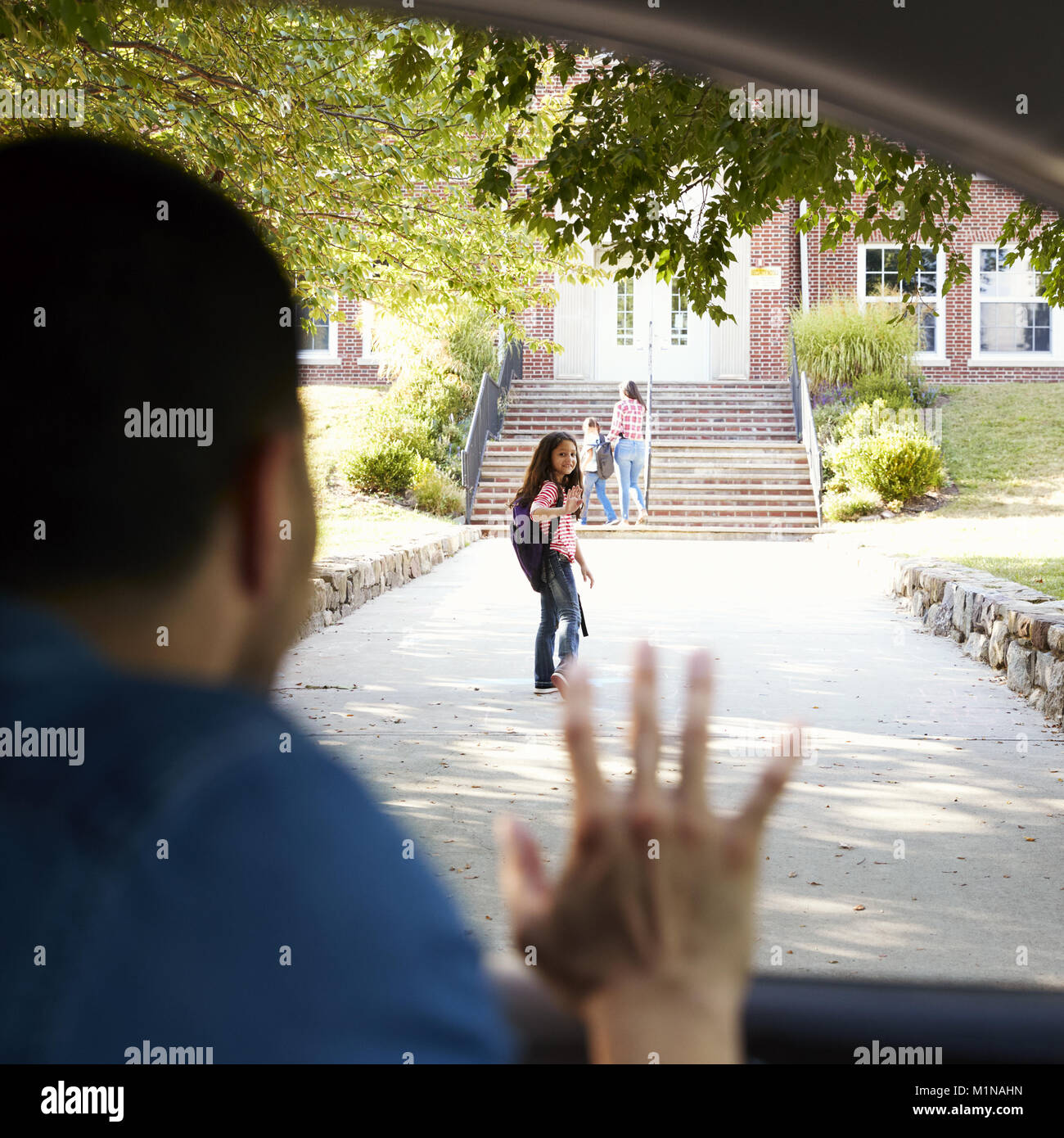 Vater im Auto Drop Off Tochter Vor Schultoren Stockfoto
