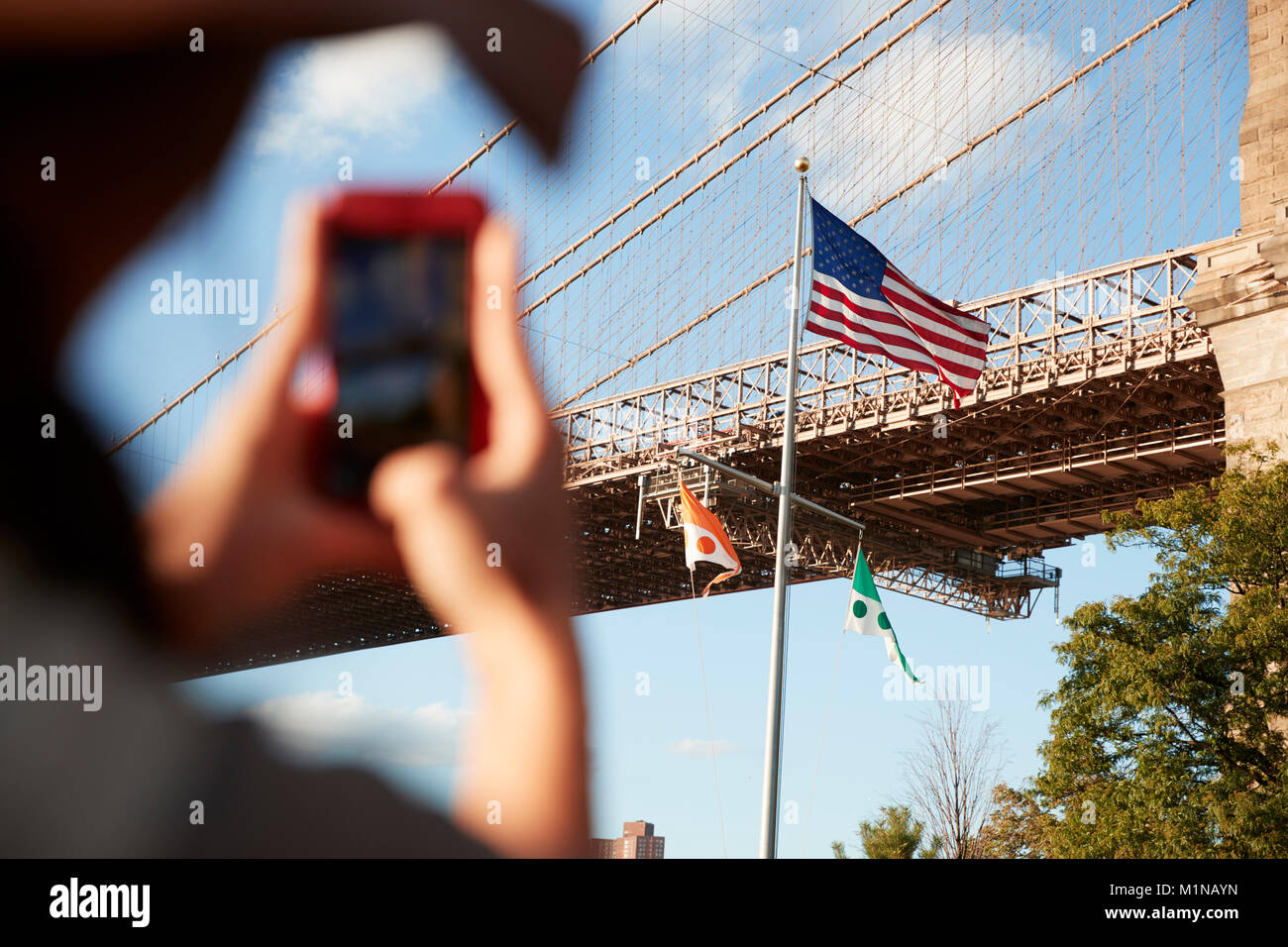 Tourist, Foto von Brooklyn Bridge auf dem Mobiltelefon Stockfoto