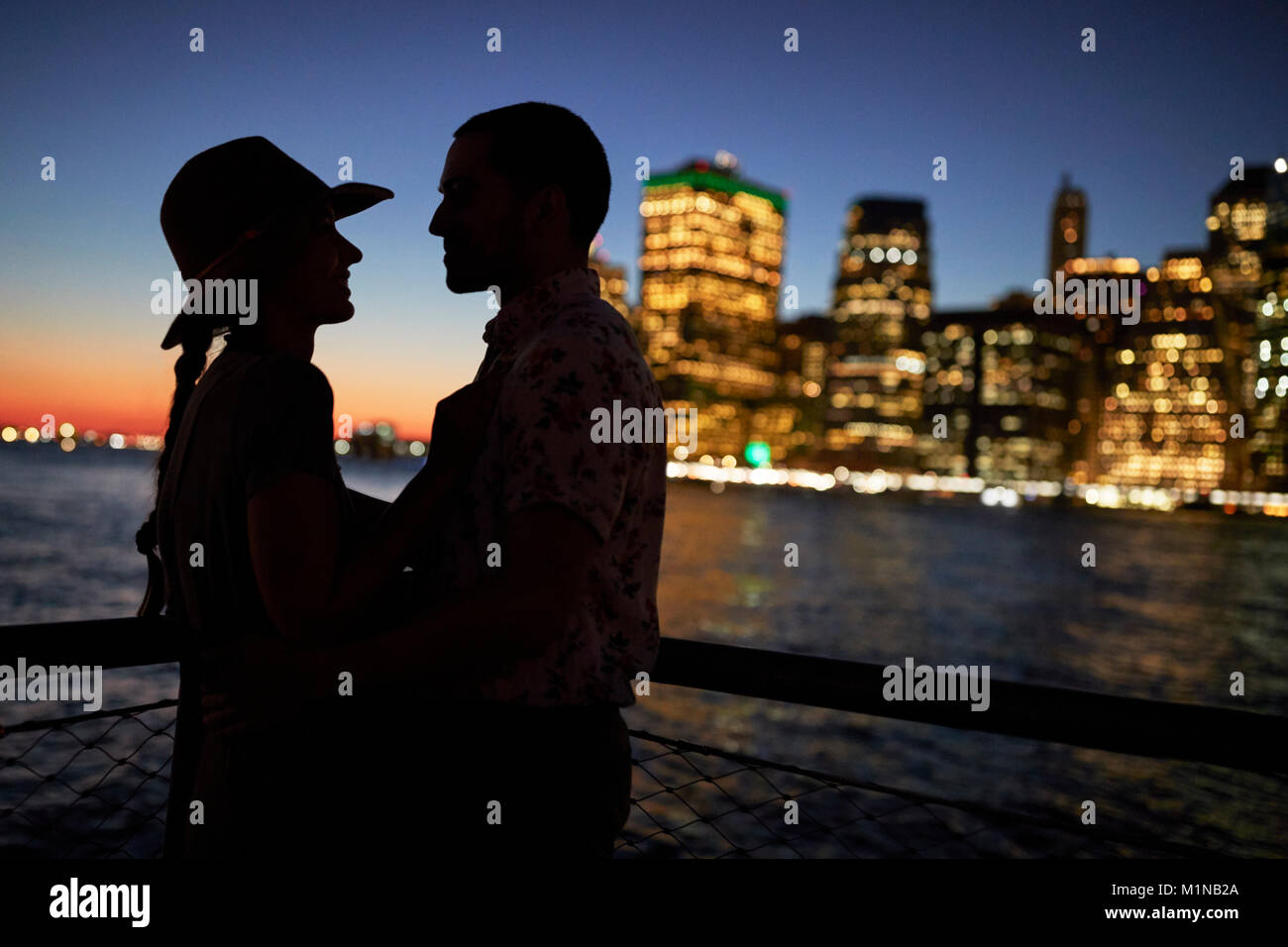 Silhouette von Romantisches Paar mit Sicht auf die City Skyline im Hintergrund Stockfoto