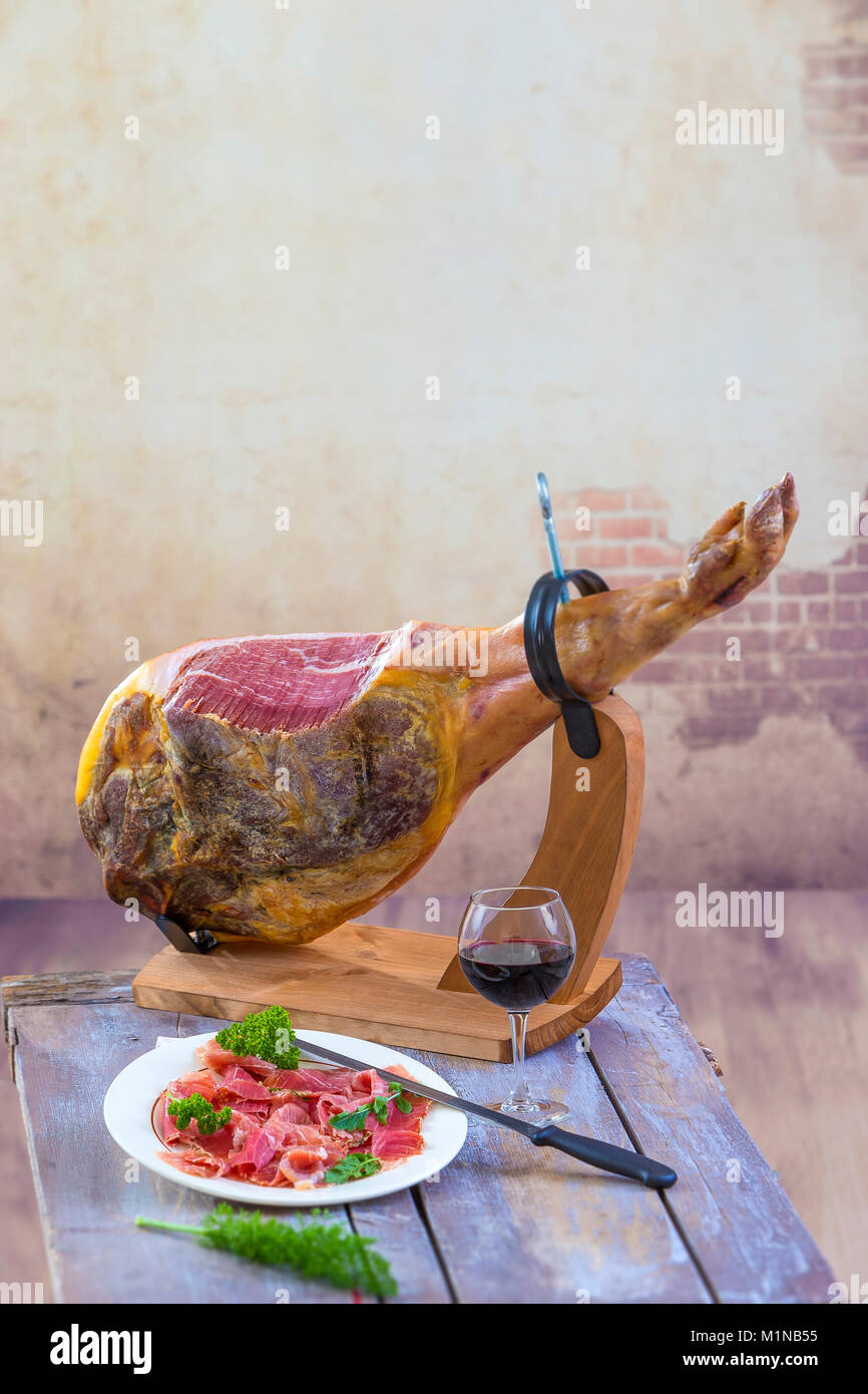 Jamon. Jamon Serrano. Traditionelle spanische Trocken spanische Schweinefleisch Schinken auf einem Teller mit Messer auf alten Vintage Holz- Hintergrund ausgehärtet Stockfoto