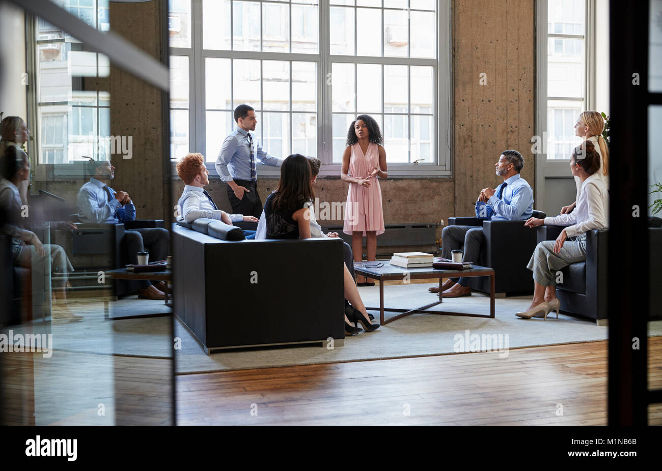 Informelles Geschäftstreffen durch offene Türen gesehen Stockfoto