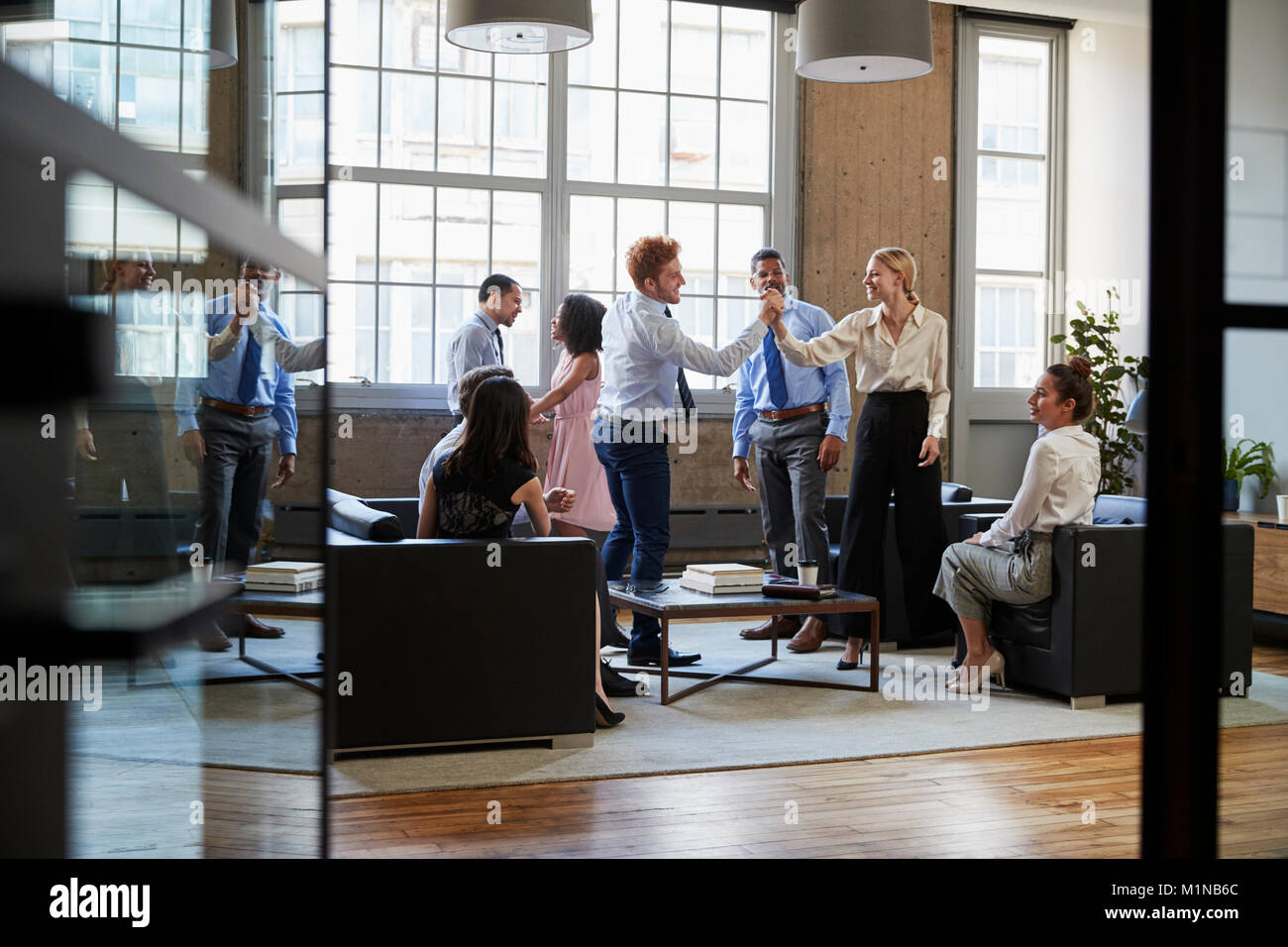 Kolleginnen und Kollegen die Hand zu treffen, die durch offene Türen Stockfoto