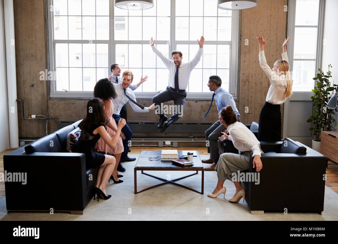 Business Team springen vor Freude am Schlagen Ziel in Sitzung Stockfoto