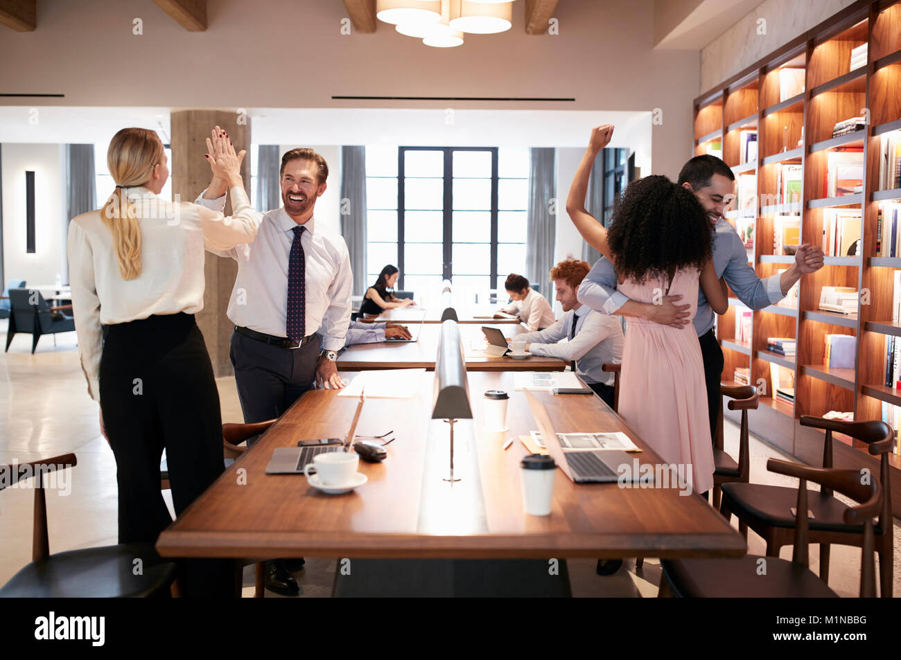 Vier Kollegen Erfolg feiern in einem Großraumbüro Stockfoto
