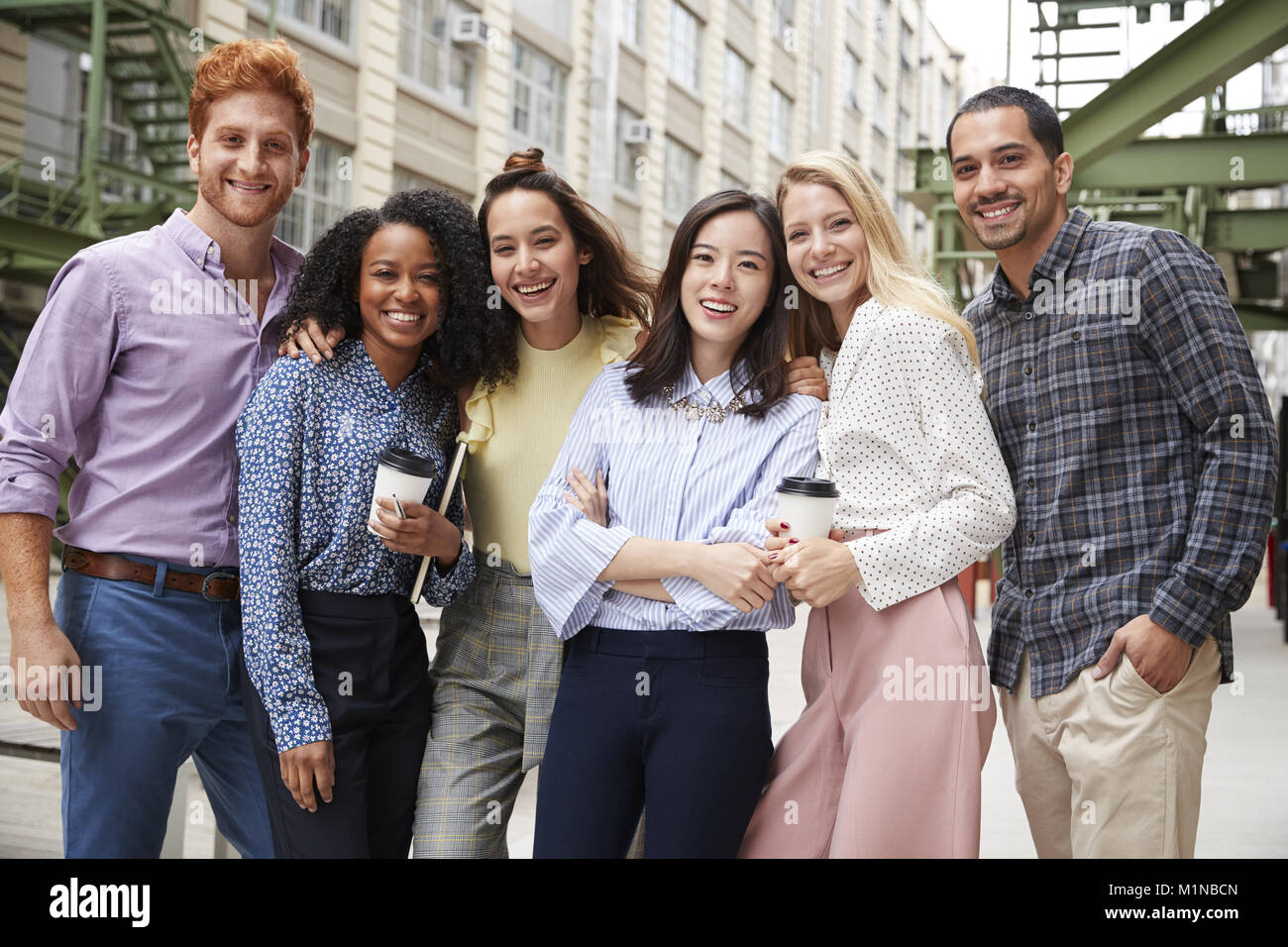 Sechs junge erwachsene Mitarbeiter stehen im Freien, Gruppe portrait Stockfoto