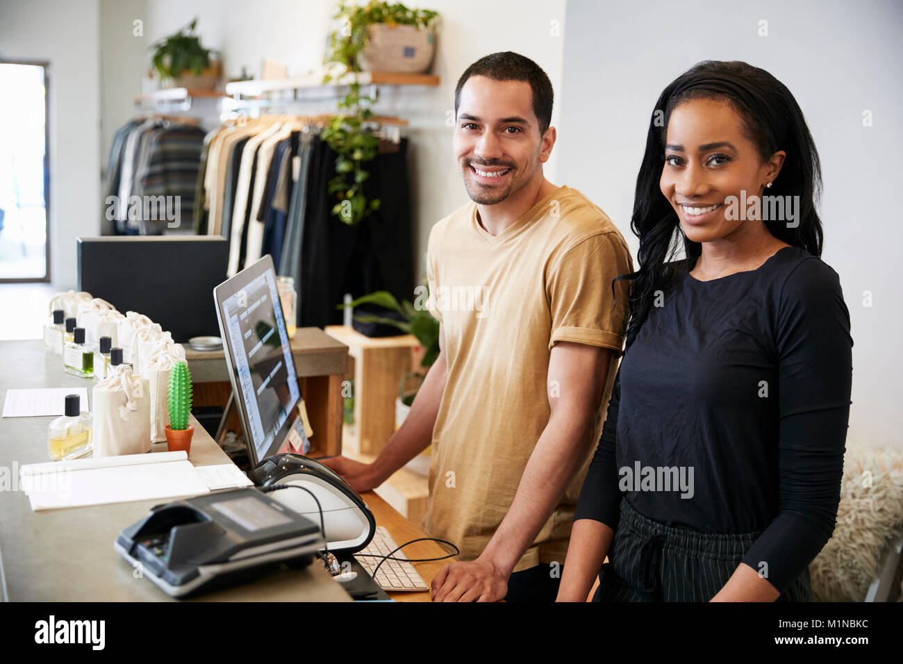 Lächelnd Kollegen hinter der Theke in Clothing Store Stockfoto