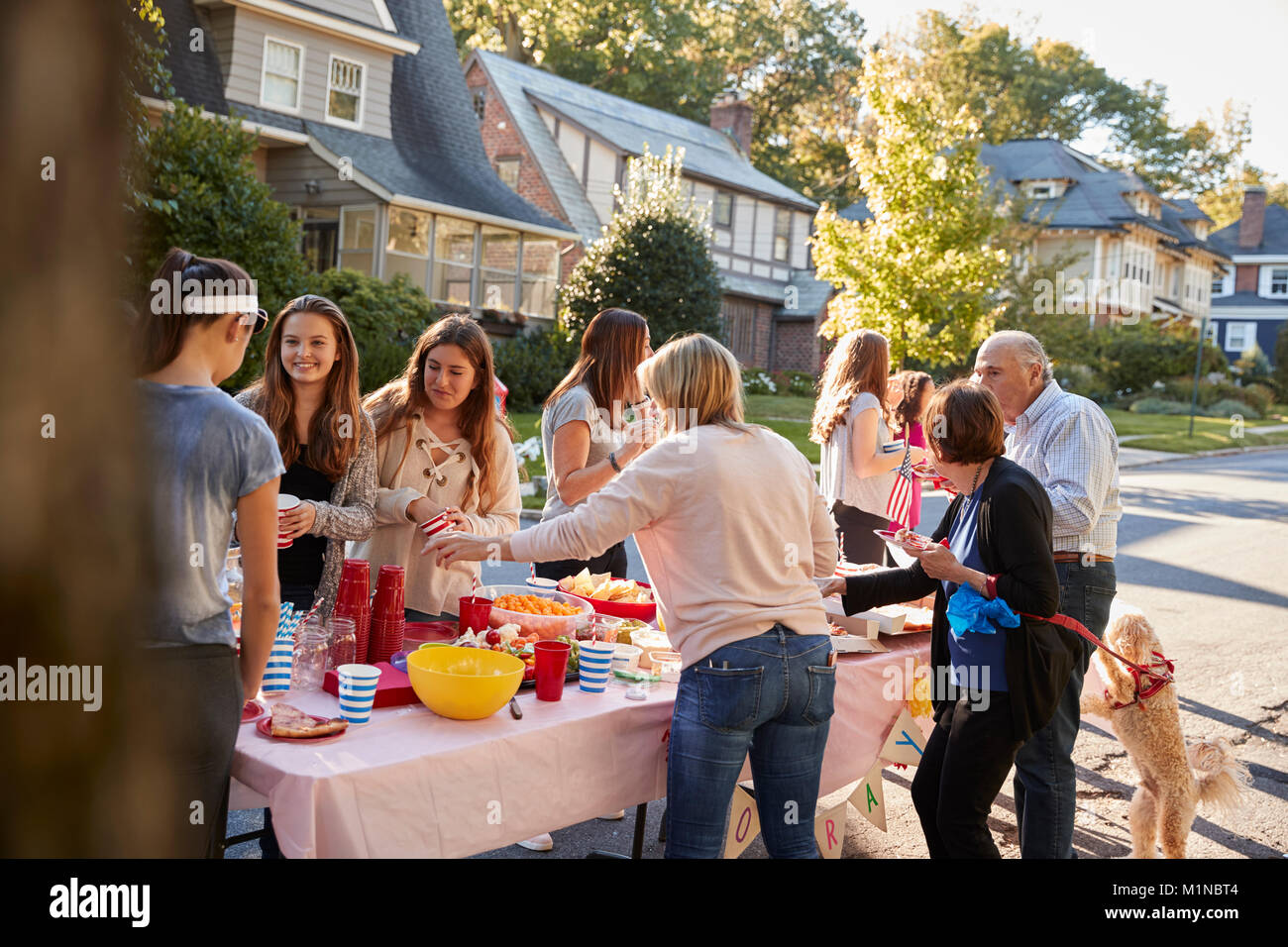 Nachbarn sprechen, um einen Tisch in einem Block Party Stockfoto