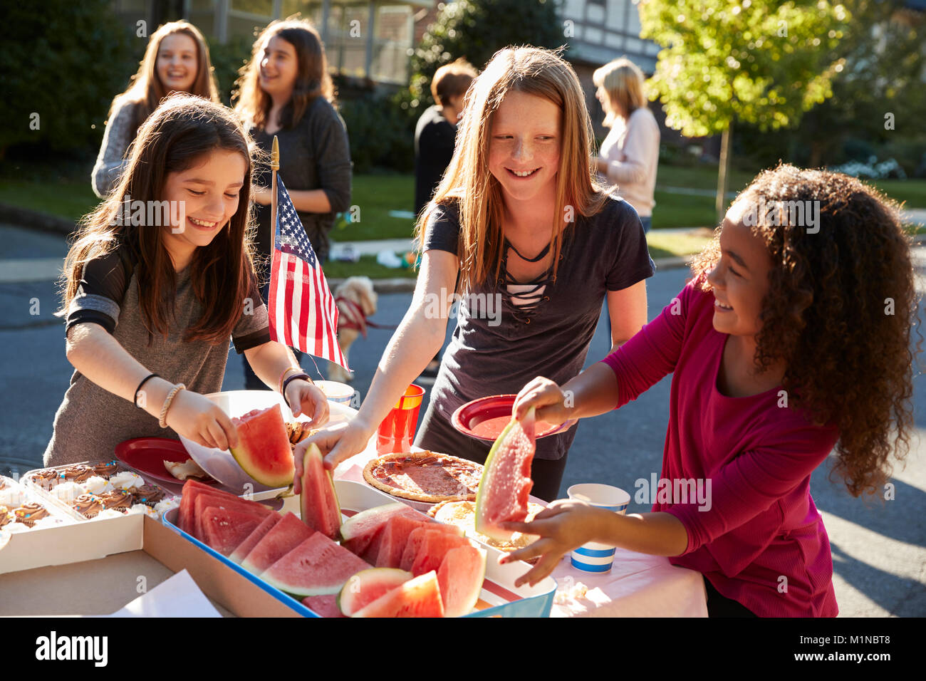 Mädchen selbst helfen zu einem Block Party zu Wassermelone Stockfoto