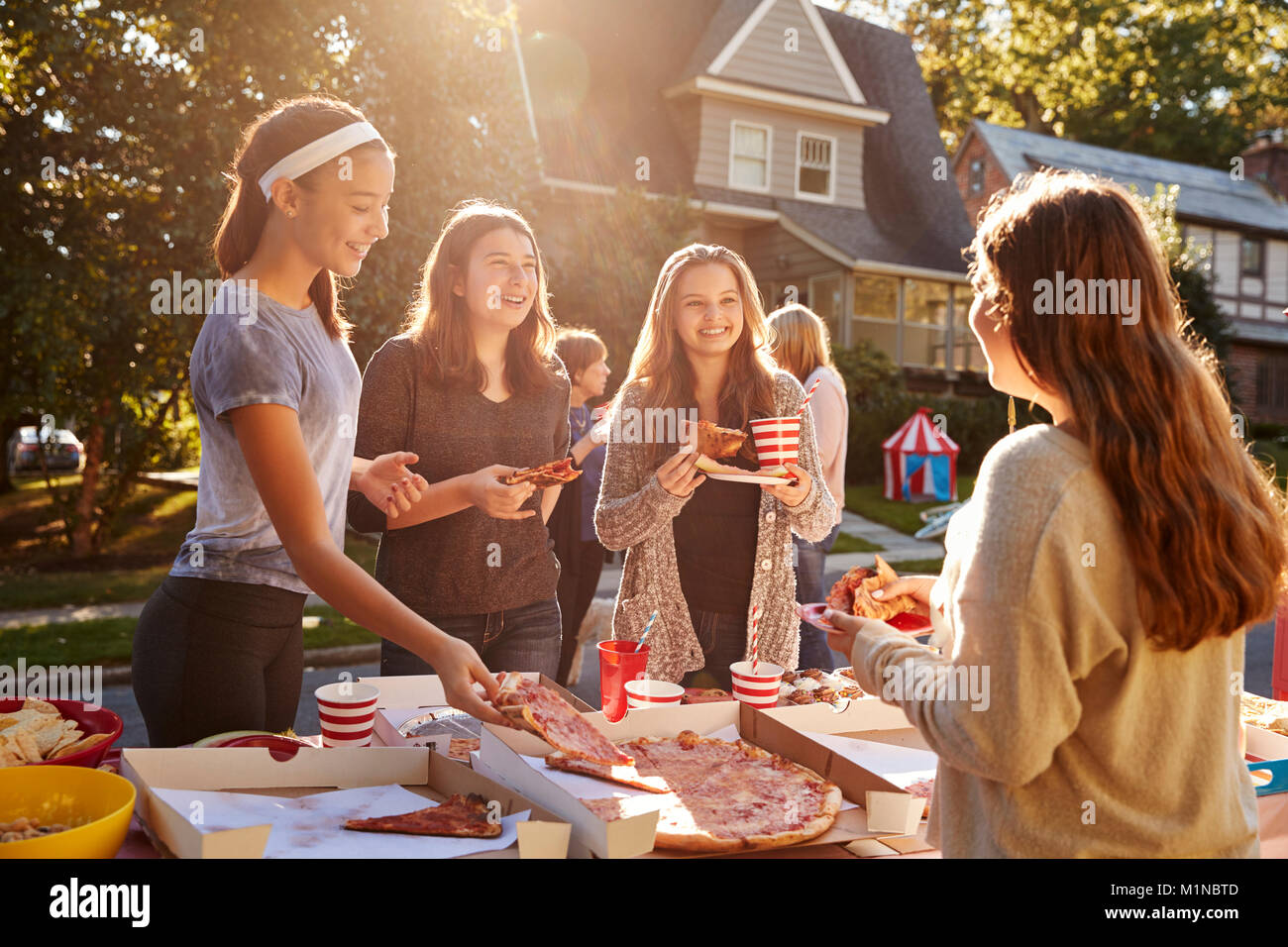 Jugendlich Mädchen essen Pizza und Sprechen zu einem Block Party Stockfoto