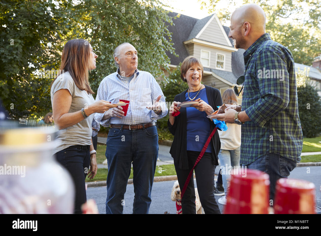 Mittleren Alters und ältere Nachbarn sprechen zu einem Block Party Stockfoto