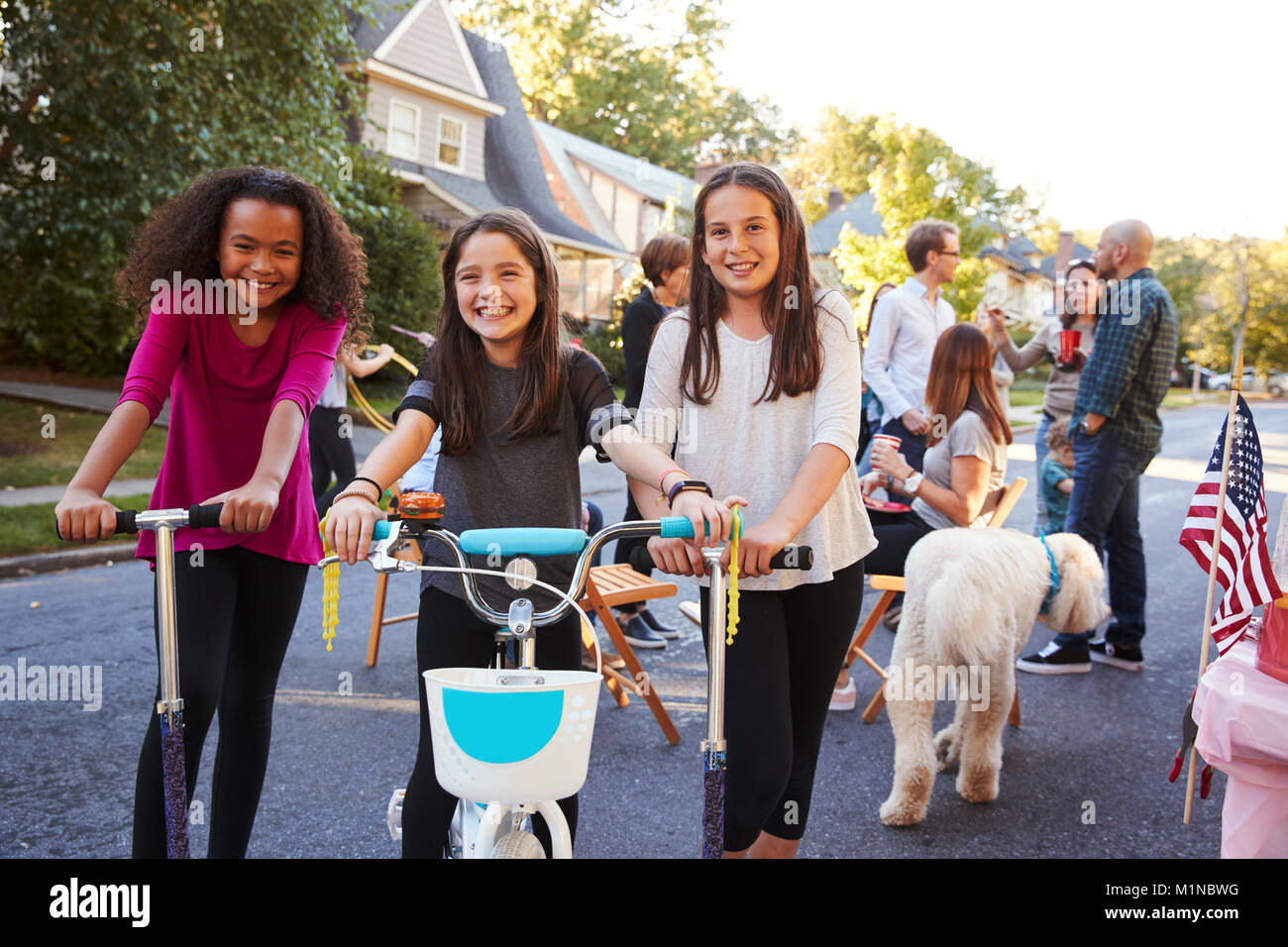 Drei vor - jugendlich Mädchen auf Roller und ein Fahrrad an einem Block Party Stockfoto