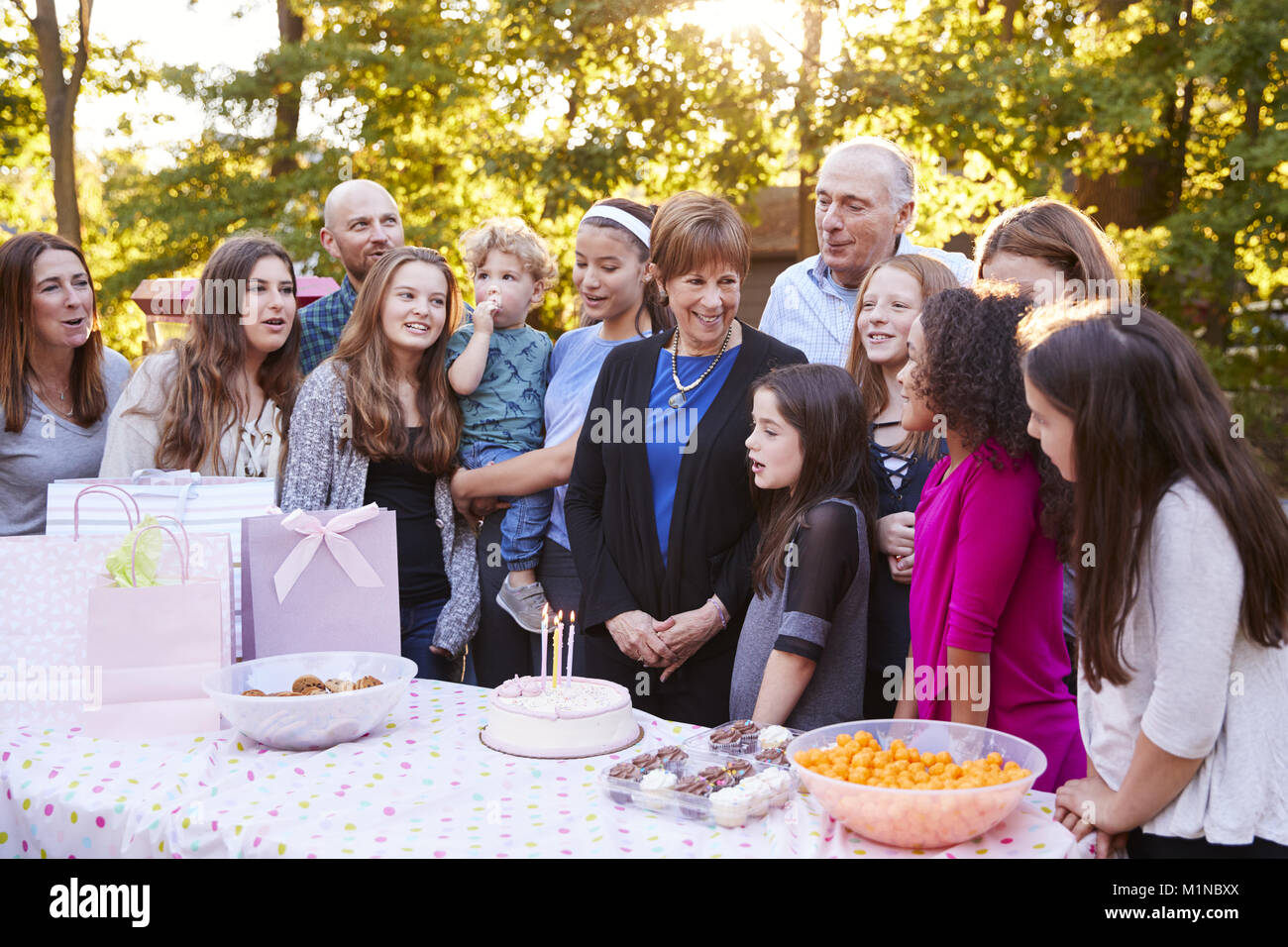 Familie und Freunde versammelten sich in einem Garten für eine Geburtstagsfeier Stockfoto