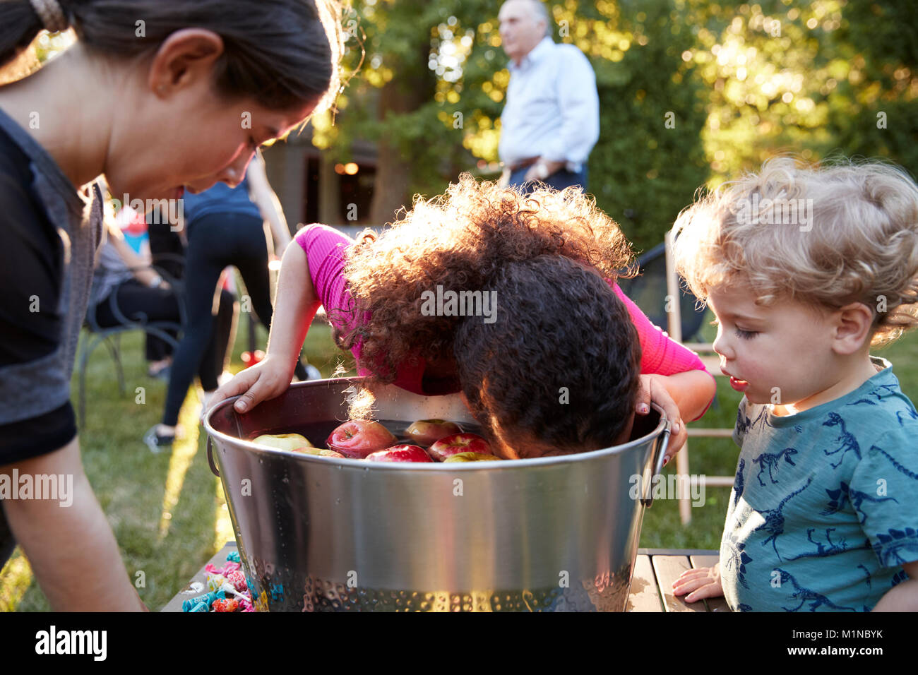 Freunde vor - jugendlich Mädchen apple bobbing im Hinterhof Partei Stockfoto