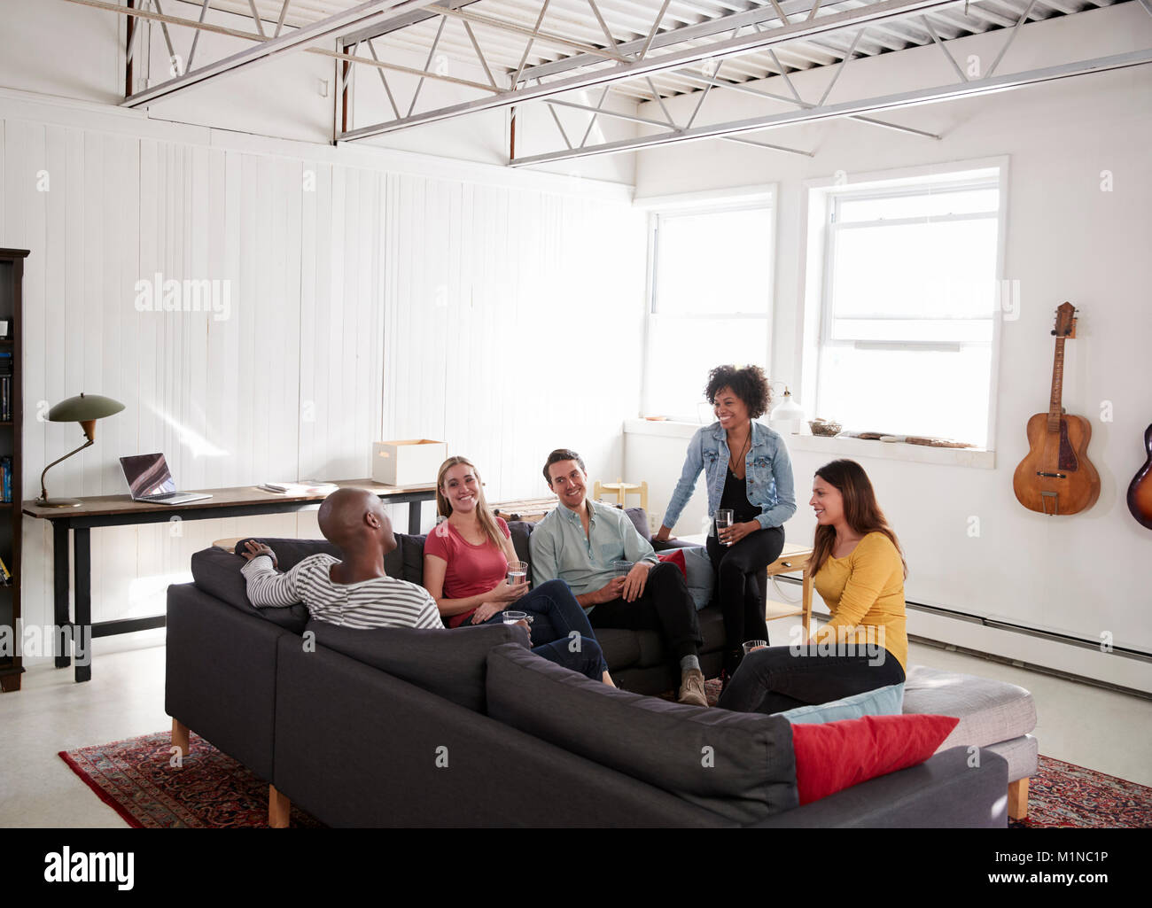 Fünf junge Freunde Geselligkeit in einem New Yorker Loft Apartment Stockfoto