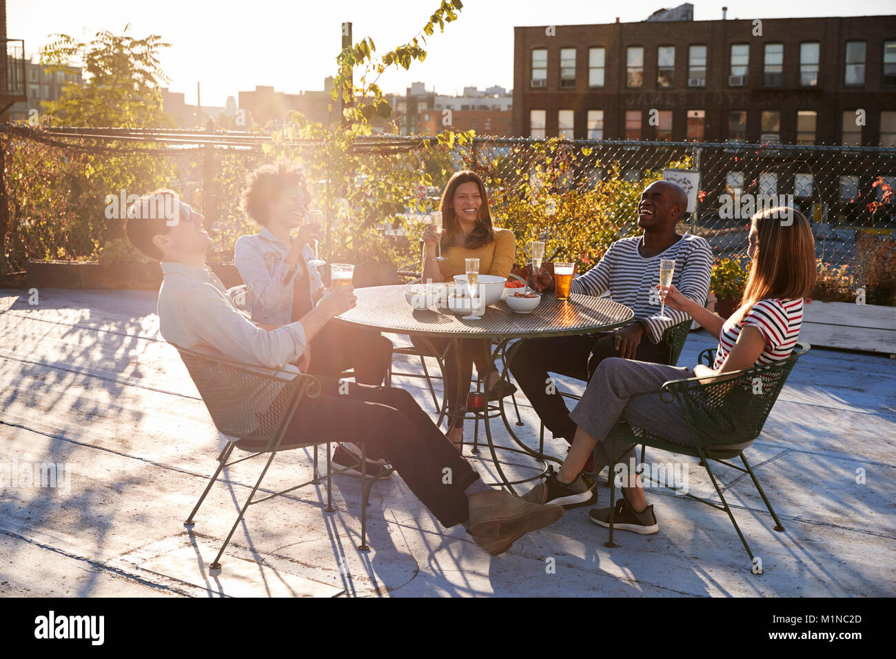 Freunde reden über Getränke auf einem New York Dachterrasse Stockfoto