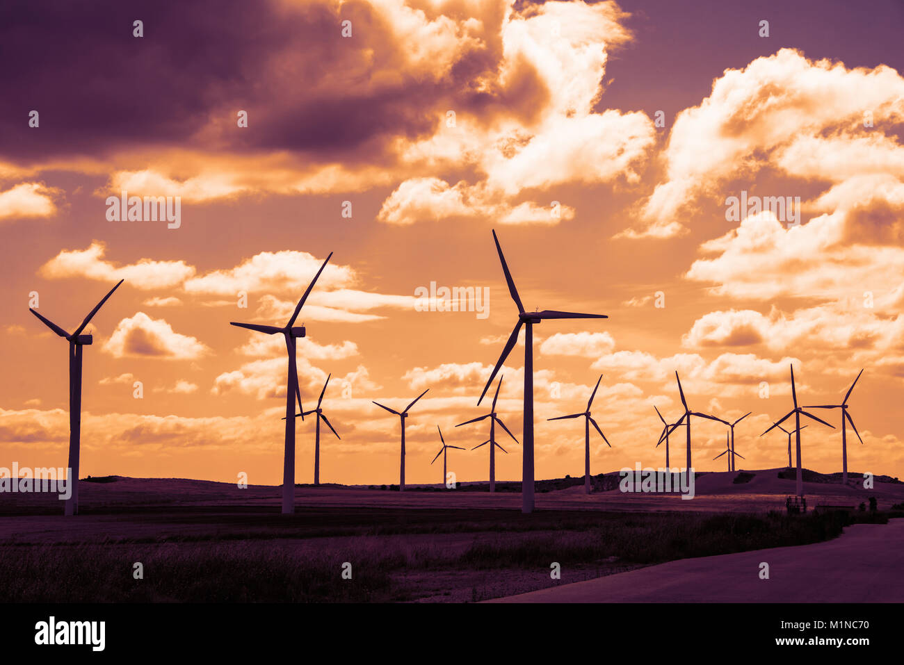 Wind Turbine Feld bei Sonnenuntergang, dramatischen Himmel Stockfoto